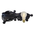 Czarna girlanda ogrodowa z gniazdami E27 i żarówką LED A60 0,5W 2100K z serii Soft Glow. Żarówka emituje ciepłe światło.