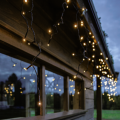 Kurtyna LED o barwie białej ciepłej zamocowana wzdłuż zadaszenia, delikatne światło tworzy świąteczny nastrój.
