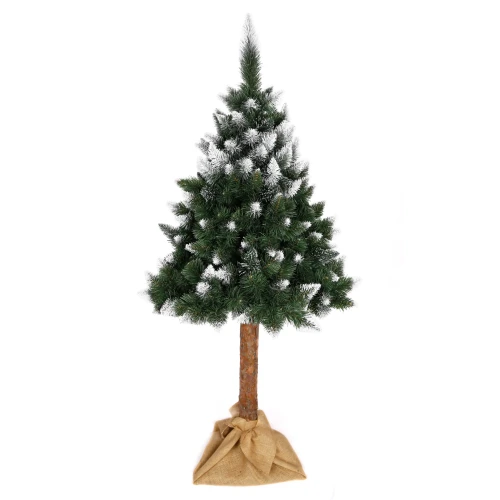Sztuczna choinka o wysokości 220 cm z gęstym igliwiem i białym efektem śnieżenia, osadzona na naturalnym pniu z jutowym workiem w podstawie.