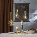 Dekoracyjne żarówki LED w złotych oprawkach wiszących i stojących ustawione na stole. Ciepłe światło tworzy elegancką, przytulną atmosferę wnętrza.