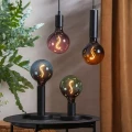 Zestaw dekoracyjnych żarówek LED E27 w różnych kolorach szkła na lampach stołowych i wiszących, nowoczesna aranżacja wnętrza z rośliną.