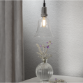 Żarówka LED filament E14 w szklanej lampie wiszącej nad stolikiem z wazonem i rośliną, subtelne oświetlenie wnętrza z ciepłym światłem.