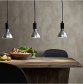 Trzy wiszące lampy z żarówkami LED E27 nad drewnianym stołem w jadalni.