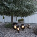 Lampa ogrodowa ORBY z kulistym kloszem w kolorze dymionym, przez który widoczna jest świecąca żarówka.