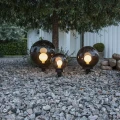 Lampa ogrodowa ORBY z kulistym dymionym kloszem i czarną podstawą do ustawienia lub wbicia w podłoże.