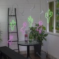Girlanda świetlna z dekoracjami LED w kształcie flamingów i kaktusów, neonowe kolory różowy i zielony, aranżacja tarasu z roślinami.