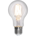 Żarówka LED E27 A60 z włączonymi filamentami emitującymi ciepłe białe światło, przezroczysta bańka i srebrny gwint.