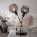 Czarna lampa stołowa z dwiema siatkowymi kloszami i żarówkami LED w nowoczesnym wnętrzu.