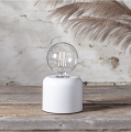 Żarówka LED G95 w lampie stołowej, przezroczysta bańka z filamentem, subtelne oświetlenie w minimalistycznej aranżacji wnętrza.