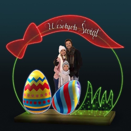 Wielkanocna ramka 3D LED z napisem „Wesołych Świąt”, kolorowymi pisankami i zieloną trawą, podświetlana dekoracja plenerowa z rodziną stojącą w środku, iluminacja świąteczna do miasta i galerii handlowych.
