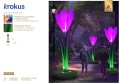 Krokus LED fotopunkt w formie dużego kwiatu z podświetlanymi różowo fioletowymi płatkami, dekoracja parkowa do zdjęć ustawiona w zielonej przestrzeni miejskiej, przyciągająca uwagę intensywnym światłem i smukłą formą rośliny. ID 145089.