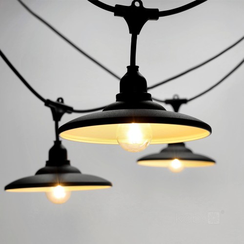 Zbliżenie na girlandę CRETE z czarnymi metalowymi kloszami i żarówkami LED E27. Widoczne ciepłe światło 2100K oraz modułowa konstrukcja przewodu z możliwością łączenia.