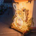 Iluminacja wielkanocna LED w kształcie zająca ustawiona przy budynku na rynku miasta, dekoracja przestrzenna przyciągająca przechodniów i tworząca miejsce do zdjęć.