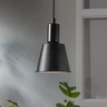 Zbliżenie na czarną żarówkę LED Decoled Dream zawieszoną w oprawie, z liściem rośliny w kadrze.