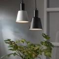 Czarna i biała żarówka LED Decoled Dream zawieszone nad zieloną rośliną. Tło w odcieniach szarości, okno i ściana.