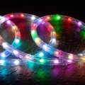 Kolorowy wąż świetlny LED RGB ułożony w pętle na mokrej powierzchni, emitujący intensywne światło w wielu kolorach – czerwonym, zielonym, niebieskim i białym