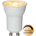 Żarówka LED GU10 z białą obudową, świecąca ciepłym światłem, oznaczenie dimmer compatible.