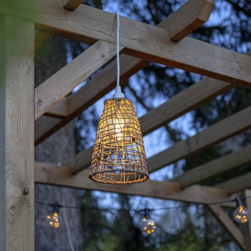 Lampa wisząca z rattanowym kloszem w altanie ogrodowej, ciepłe światło LED tworzy przytulny nastrój.