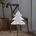 Biała dekoracja LED w kształcie choinki, podświetlana ciepłym światłem, zawieszona na oparciu drewnianego krzesła w przytulnym domowym wnętrzu.