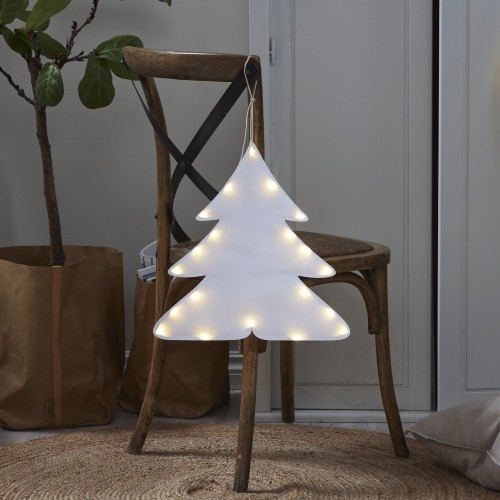 Biała dekoracja LED w kształcie choinki, podświetlana ciepłym światłem, zawieszona na oparciu drewnianego krzesła w przytulnym domowym wnętrzu.