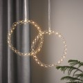 Dwa wianuszki LED w kolorze chromu o subtelnej, ażurowej formie i ciepłym świetle, zawieszone obok siebie na delikatnych dekoracyjnych taśmach.