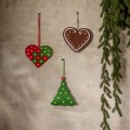 Trzy wiszące ozdoby LED w świątecznych kształtach — dwa serca i zielona choinka z podświetlanymi gwiazdkami — zawieszone na jasnej ścianie obok gałązek iglastych.