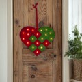 Dekoracja świąteczna LED w kształcie czerwono-zielonego serca, zawieszona na drewnianych drzwiach. Ozdoba świeci ciepłym światłem i tworzy przytulny, bożonarodzeniowy akcent we wnętrzu.