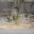 Dwie świetlne korony LED ustawione na odświętnie nakrytym stole. Ciepły blask wprowadza elegancki, przytulny nastrój na świąteczną kolację.