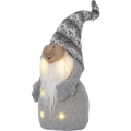 Świąteczny skrzat LED w szarej czapce melanżowej i szarym stroju, z długą białą brodą i delikatnym ciepłym podświetleniem na tułowiu. Dekoracja stojąca, utrzymana w stonowanej zimowej kolorystyce.
