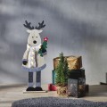 Drewniany renifer LED z podświetlanym futrzanym szalikiem i choinką z czerwoną świecącą gwiazdką, ustawiony przy prezentach i małej choince, ociepla świąteczny kącik w salonie.