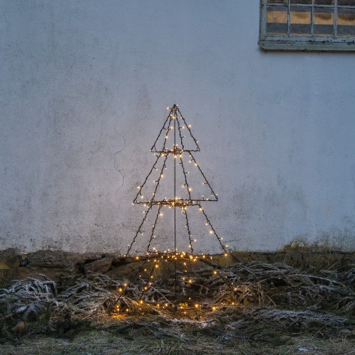 Choinka LED na metalowym stelażu, smukła dekoracja ogrodowa z ciepłym światłem, ustawiona przy jasnej ścianie budynku, subtelnie rozświetlająca zimową aranżację.