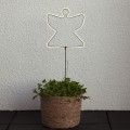 Dekoracja NEON LED w kształcie anioła na metalowym stelażu, świecąca jasnym światłem, umieszczona w donicy owiniętej jutą. Nastrojowa ozdoba do wnętrz oraz przestrzeni zewnętrznych.