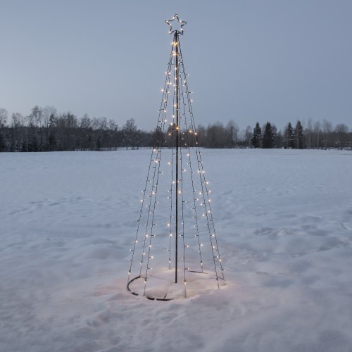 Smukła choinka świetlna LED w formie metalowego stelaża z gwiazdą na szczycie, ustawiona na śnieżnym polu. Ciepłe punkty światła delikatnie rozświetlają zimowy krajobraz o zmierzchu.