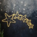Świąteczna dekoracja LED w kształcie komety z gwiazdami zawieszona na przewodzie na tle zimowej aranżacji delikatne światło podkreśla kontur dekoracji i tworzy nastrojowy świąteczny klimat.
