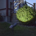 Solarny reflektor ogrodowy LED z widocznym panelem solarnym, oświetlający rośliny przy elewacji.