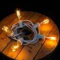 Girlanda ogrodowa z żarówkami LED filament nawinięta na drewnianą szpulę, ciepłe światło dekoracyjne.