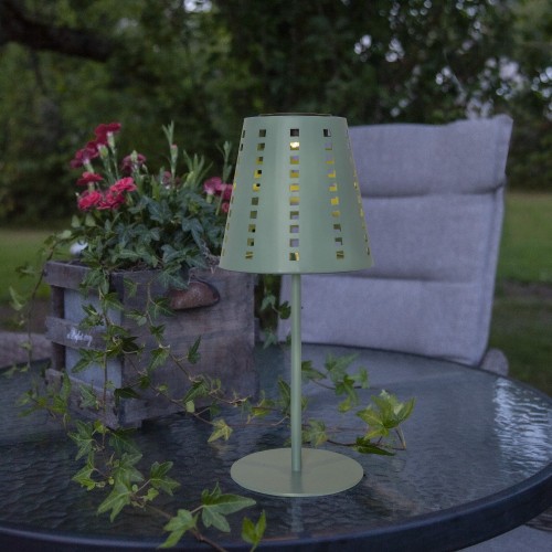 Solarna lampa stołowa ogrodowa LED zielona, oświetlenie tarasu na stoliku wśród roślin.