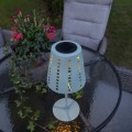Solarna lampa stołowa ogrodowa LED zielona na stole ogrodowym, widok z góry, oświetlenie przestrzeni wypoczynkowej.