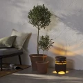 Nastrojowa solarna lampa LED do ogrodu z funkcją ładowania USB, ustawiona przy donicach i fotelu, tworząca przytulne oświetlenie tarasu.