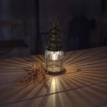 Stylowa lampa w kształcie latarni emitująca ciepłe światło, ustawiona na drewnianym stole i tworząca efektowne refleksy świetlne w pomieszczeniu.