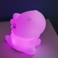 Lampka nocna dinozaur w różowym odcieniu światła, dodająca uroku i delikatnego klimatu do wnętrza.