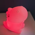 Lampka nocna dinozaur w intensywnym czerwonym kolorze światła, idealna do stworzenia wyjątkowej atmosfery wieczorem.