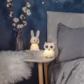 Lampki nocne zwierzątka z ciepłym, miękkim światłem, ustawione obok łóżka, zapewniają subtelne oświetlenie i przyjazną atmosferę przed snem.