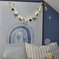 Łańcuch świetlny Pippi rozwieszony nad łóżkiem, delikatnie podświetla przestrzeń i buduje spokojny nastrój wieczorem.