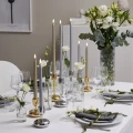 Świece LED w odcieniach srebra i złota ustawione na nakrytym stole, podkreślają elegancki charakter aranżacji i tworzą nastrojową atmosferę.