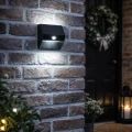 Solarny kinkiet z czujnikiem ruchu skutecznie oświetla przestrzeń przy wejściu, podkreślając detale ceglanej elewacji i zwiększając komfort poruszania się po zmroku.