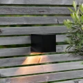 Kompaktowy kinkiet solarny zamontowany na ogrodzeniu, subtelnie rozświetla przestrzeń i zwiększa komfort korzystania z niej po zmroku.