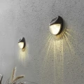 Lampy solarne LED zamontowane na ścianie w odstępach, tworzące spójny efekt świetlny i subtelne podświetlenie przestrzeni.