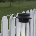 Solarny kinkiet ogrodowy LED montowany na ogrodzeniu zapewnia praktyczne oświetlenie przestrzeni wokół domu i ścieżek.