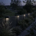 Solarne lampy LED zamontowane na ogrodzeniu oświetlają przestrzeń ogrodu i ścieżkę tworząc nastrojowe światło po zmroku.